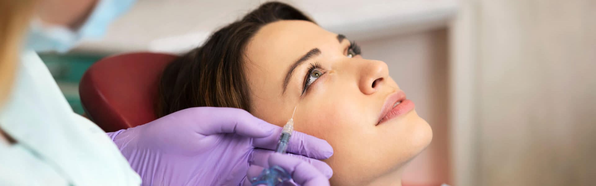 Young woman on a beauty treatment with the filler injection at the beauty clinic