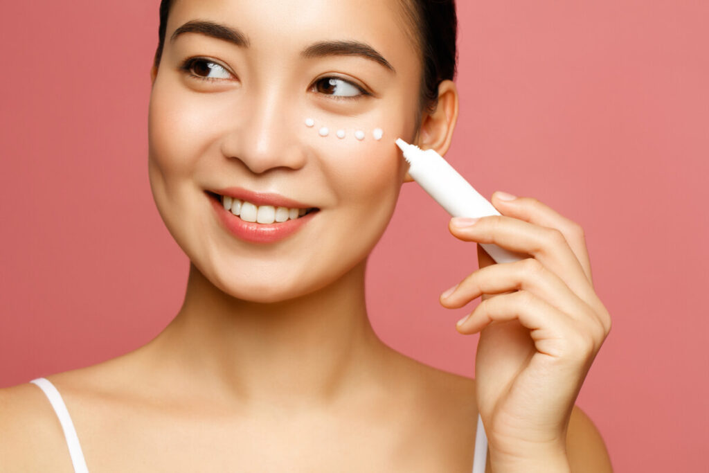 young woman applying eye lifting cream