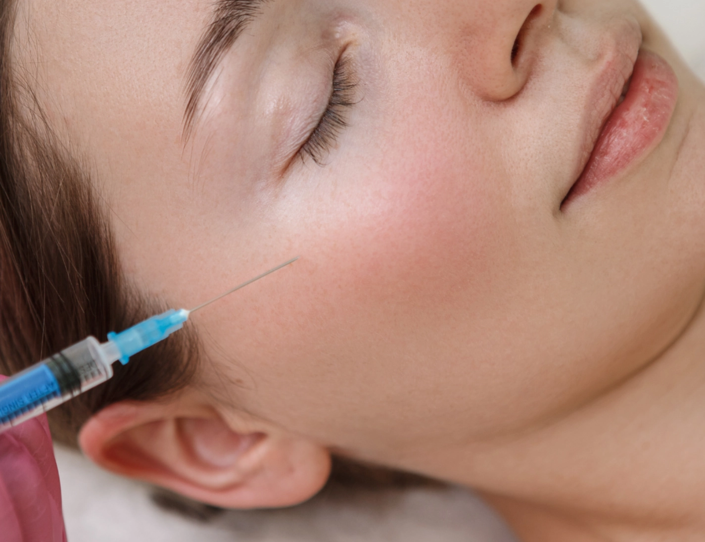 A woman receiving a SKINVIVE injection in her cheek. The image shows a close-up of the injection site and the woman's face.