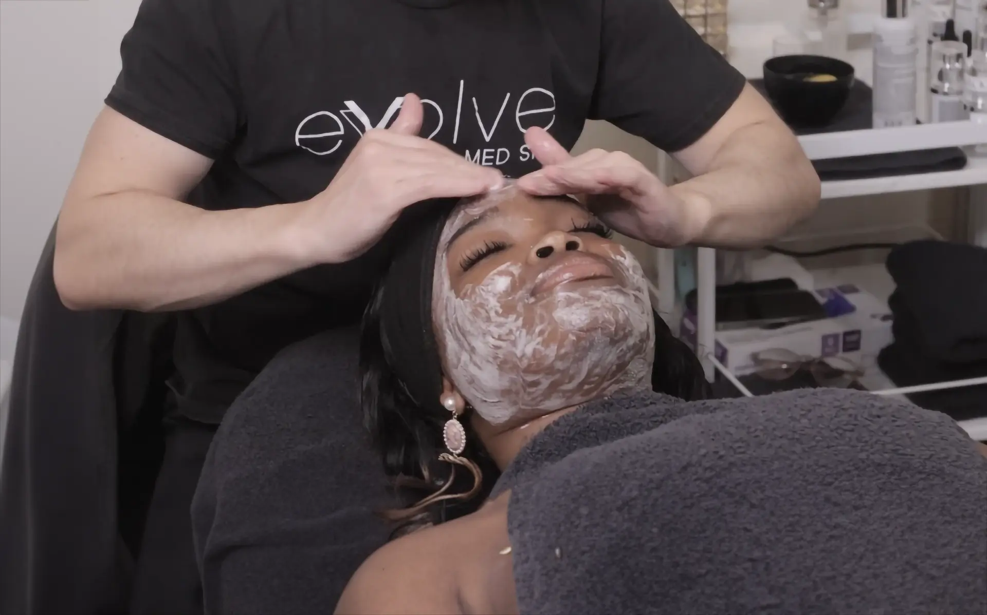 Woman receiving a chemical peel treatment at Evolve Med Spa, with a professional applying the peel to her face.